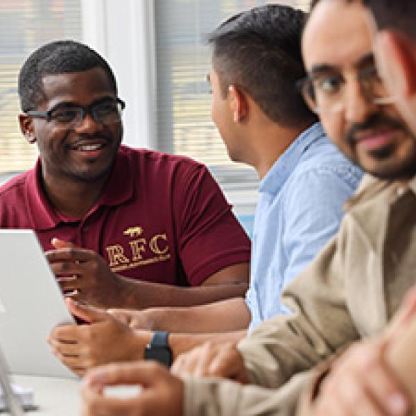Group of students meeting and reviewing information on an ipad