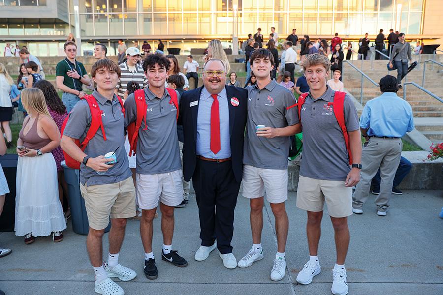 Dean Ryan poses with four male lacrosse players